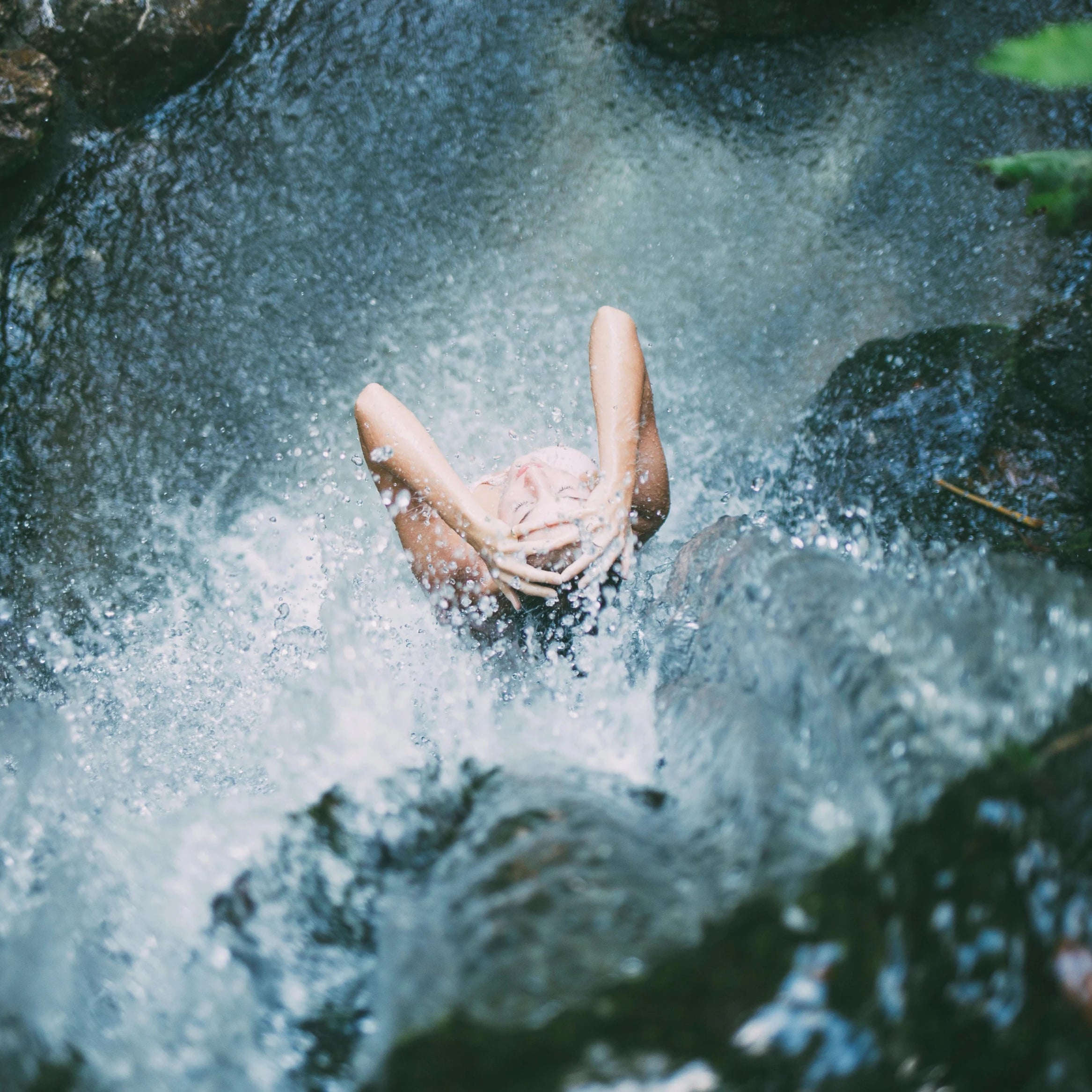 Femme qui se lave les cheveux sous une cascade d'eau dans une rivière, nature, relax, bio bien-être