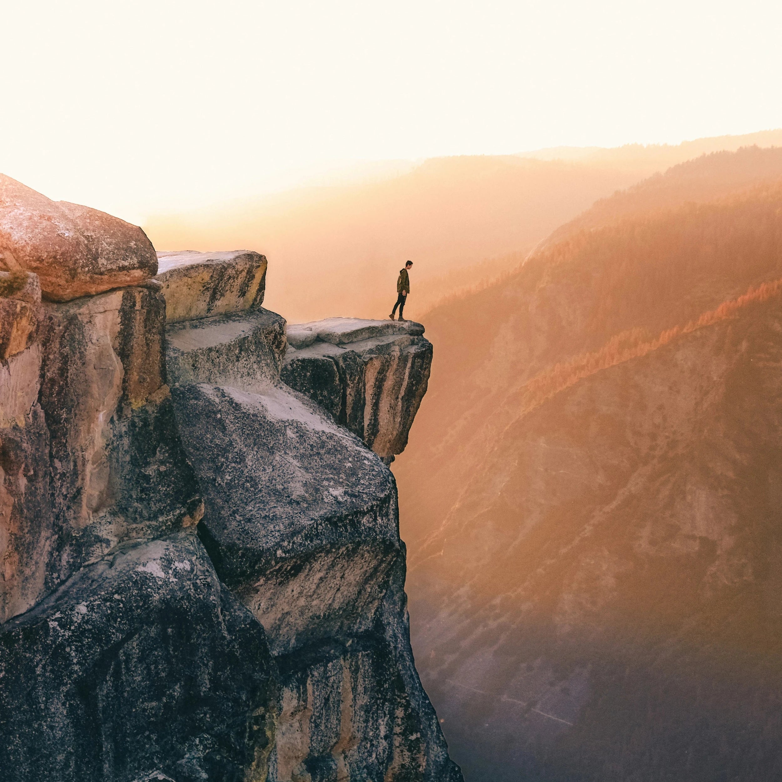 Homme en randonnée en haut d'une falaise au coucher de soleil, sport, nature, bien-être