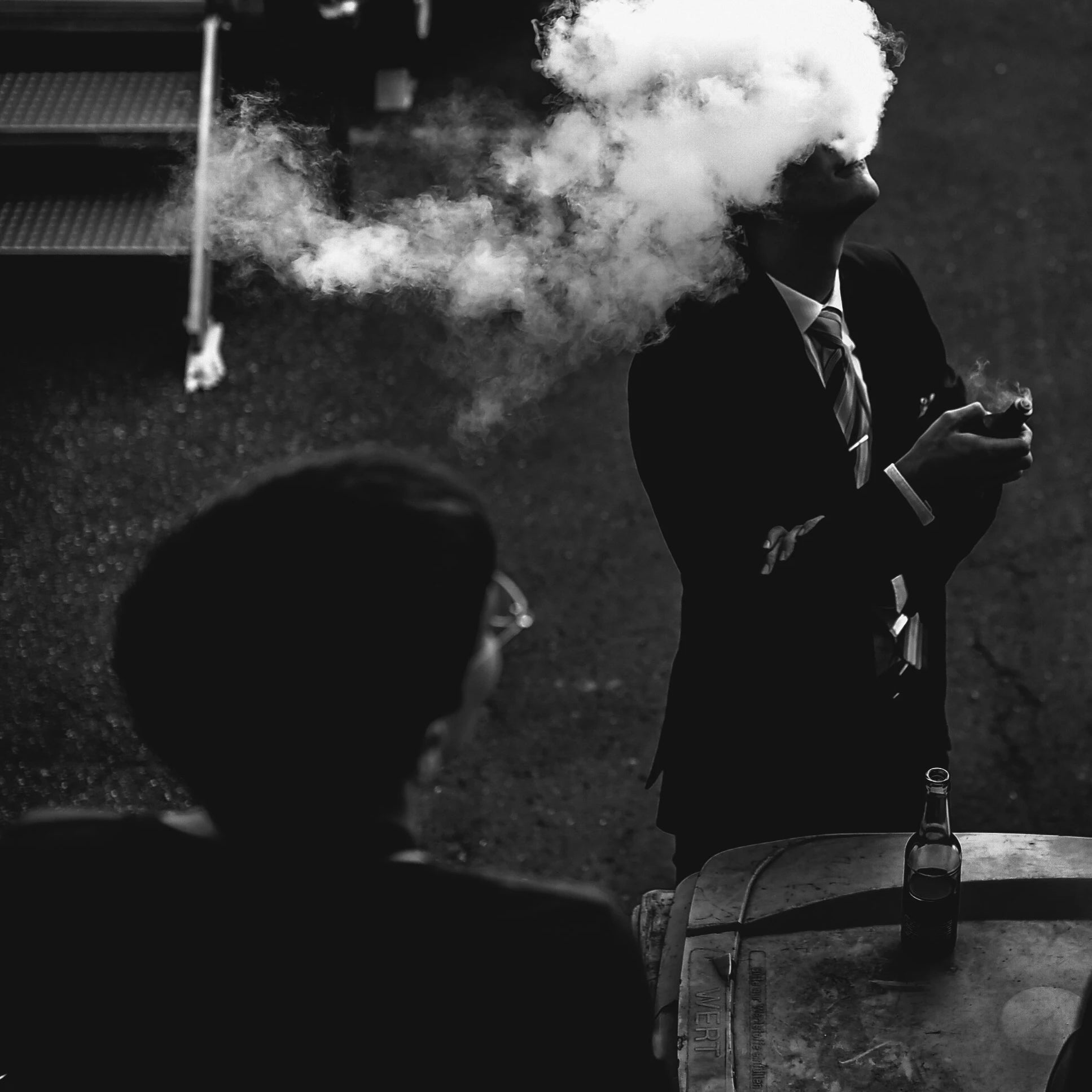 Homme en noir et blanc qui vapote avec un nuage de fumée, smoker