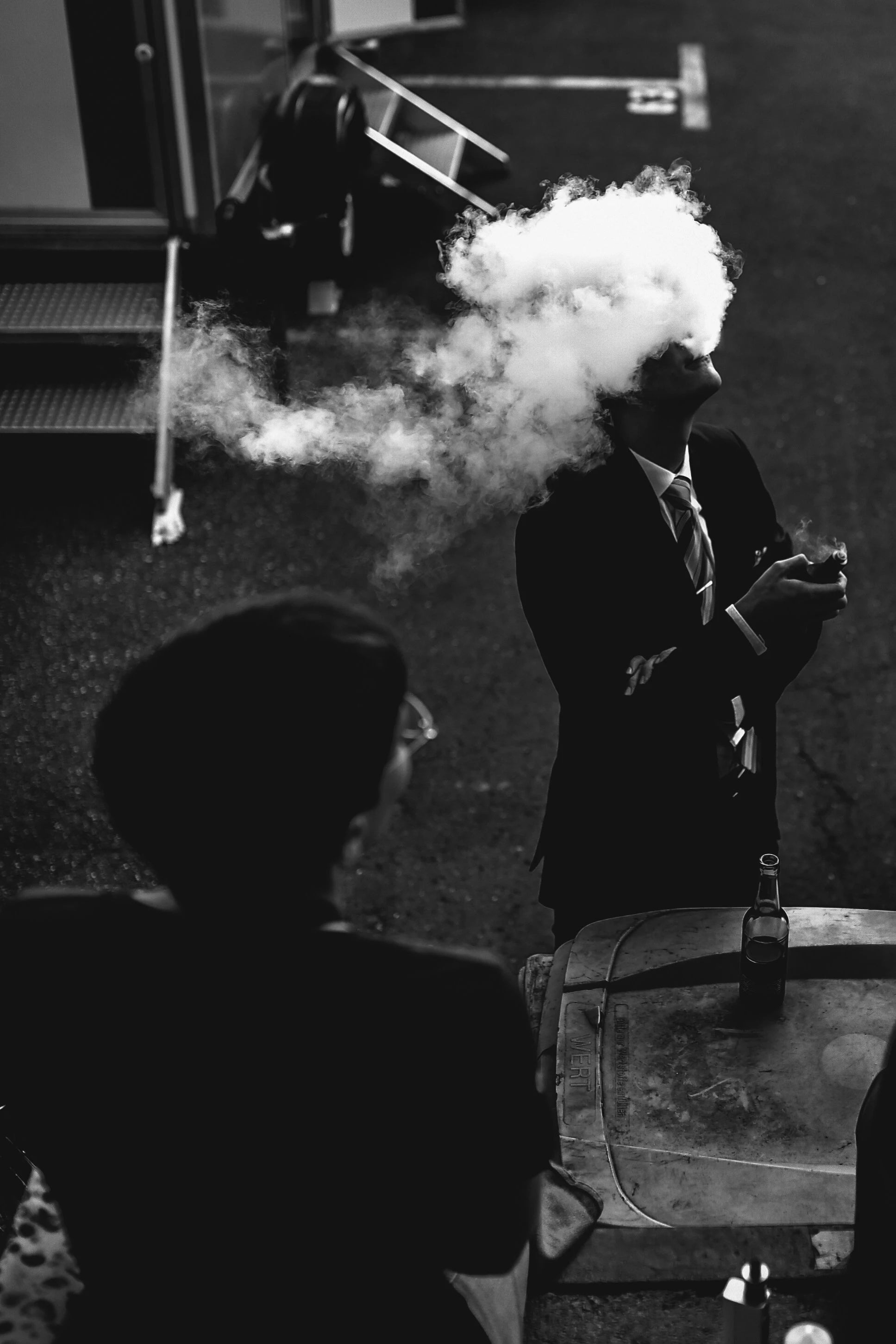 Homme en noir et blanc qui vapote avec un nuage de fumée, smoker