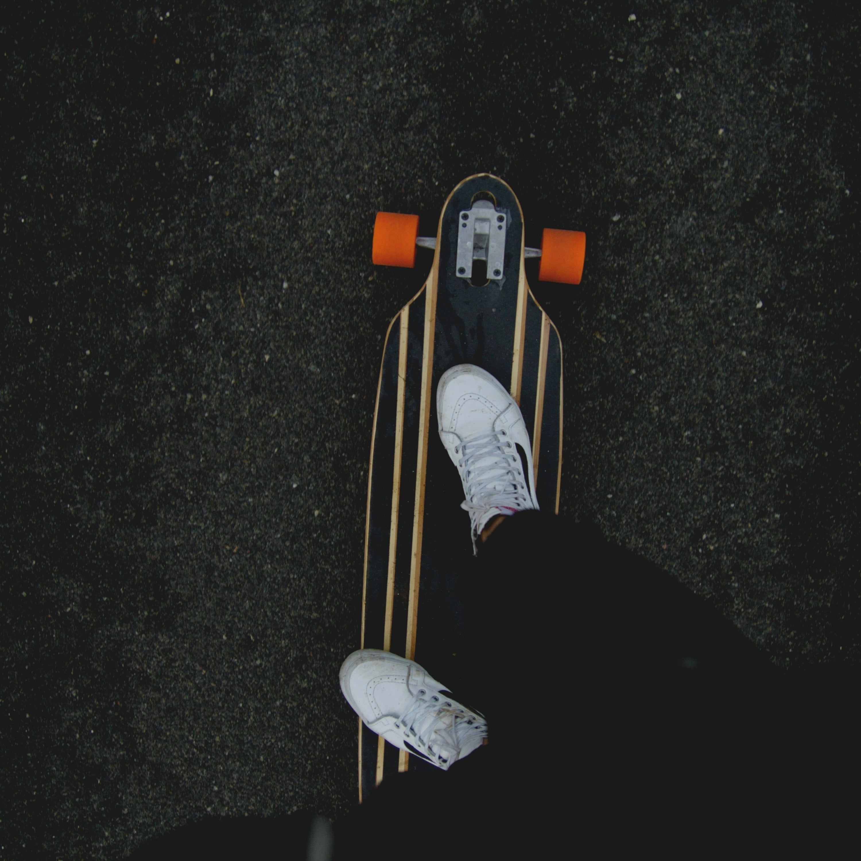 Pieds d'un skater sur sa planche sur la route, skate life