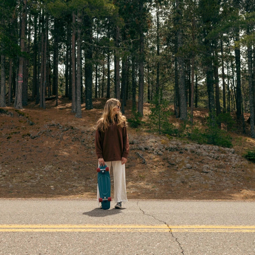 Femme avec un skate au bord de la route, détente chill
