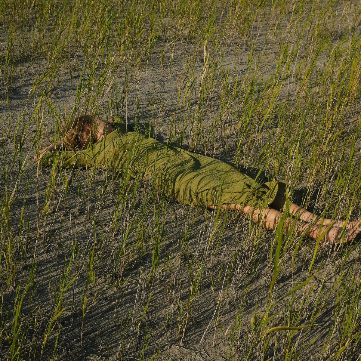 Femme habillée en vert qui dort dans un champ de riz vert, sommeil, détente