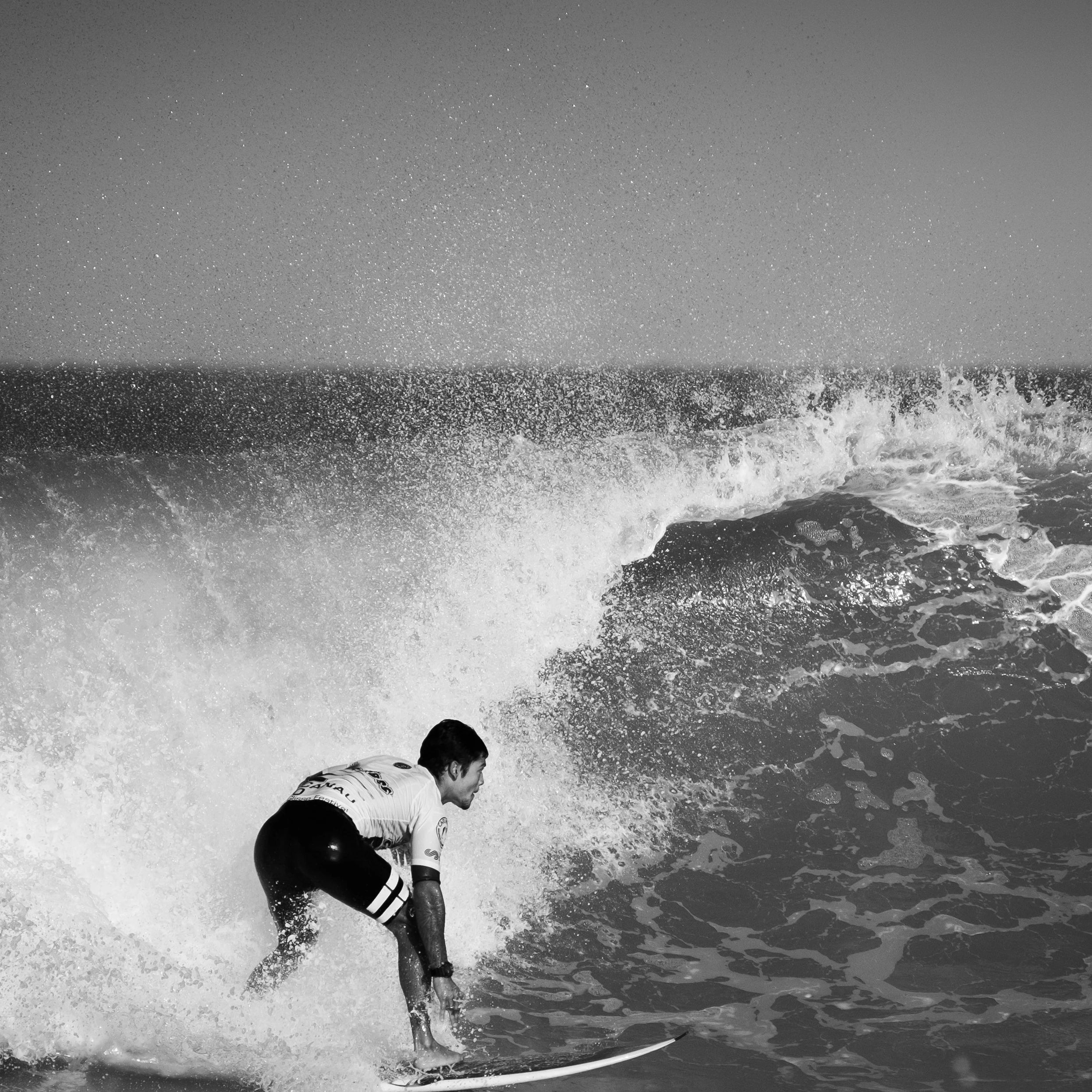 Surfeur dans une vague pendant une compétition en noir et blanc, relax, sport