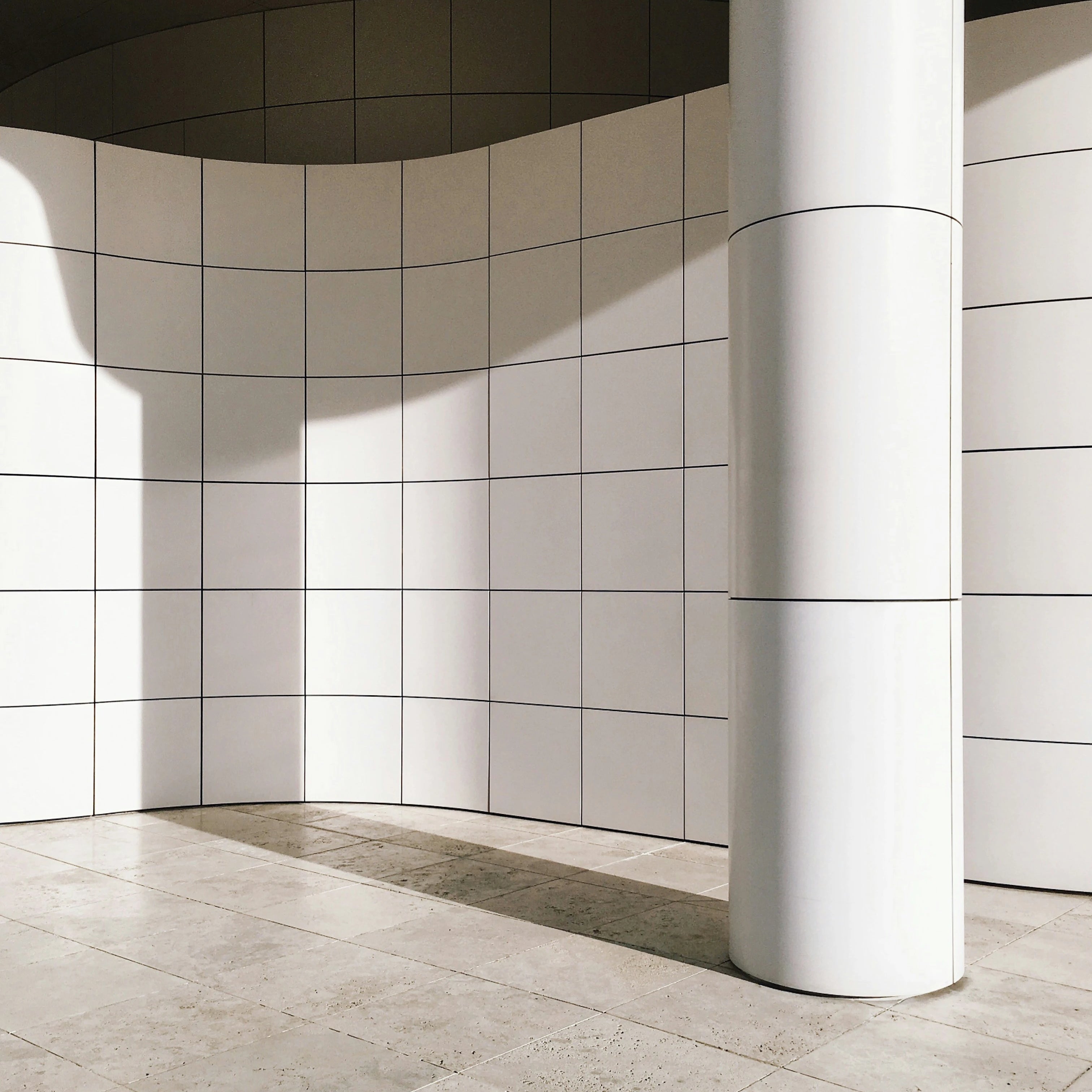 Mur extérieur en carrelage blanc carré et sol en travertin, naturel