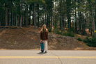 Femme avec un skate au bord de la route, détente chill