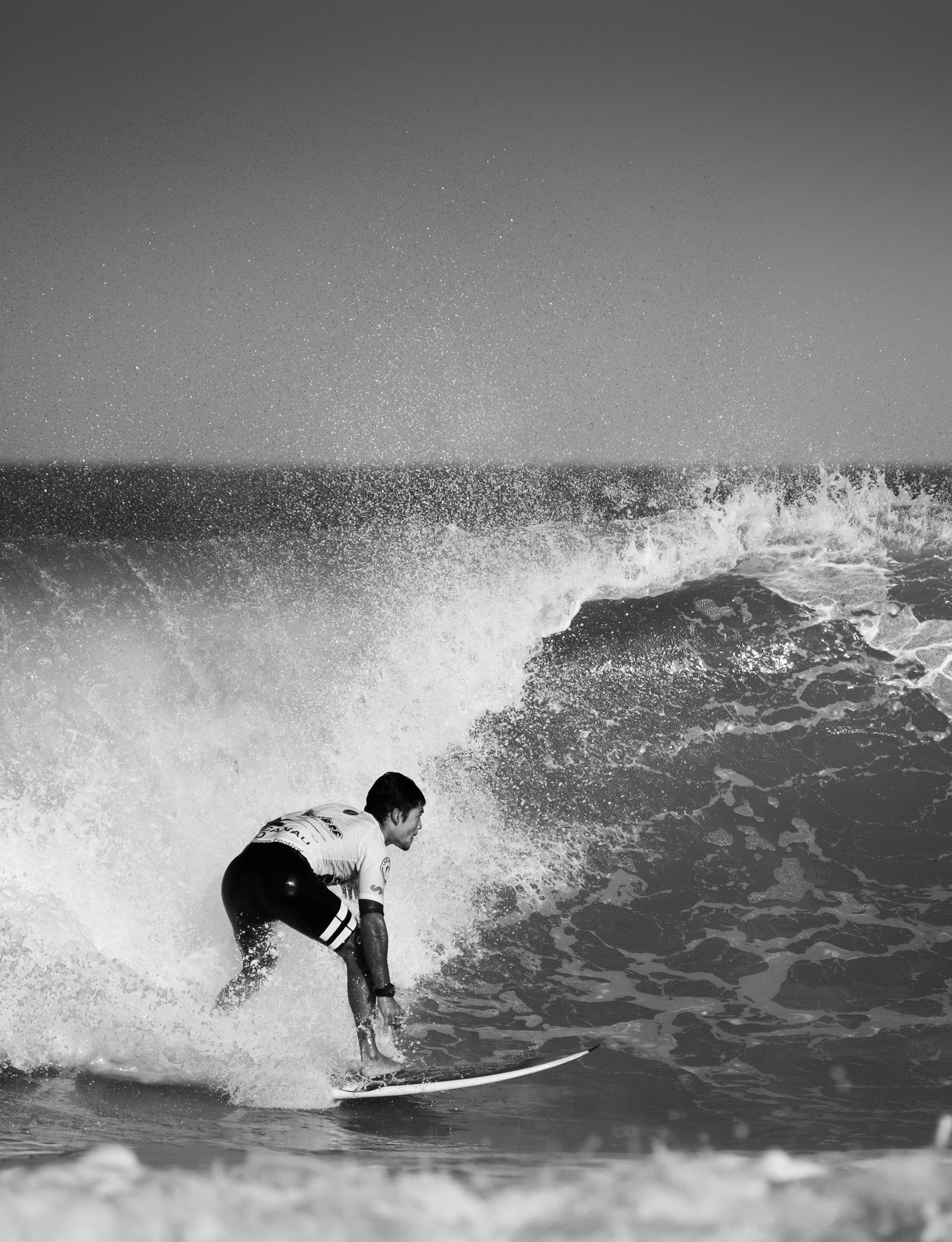 Surfeur dans une vague pendant une compétition en noir et blanc, relax, sport